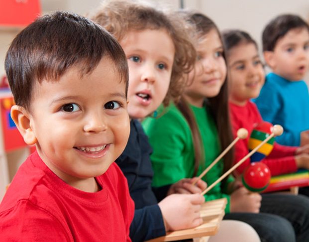 Line of Preschool Children smiling with instruments in their hands.