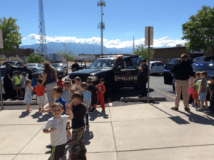 Preschool Children Standing in line in front of a Police car for summer activities.