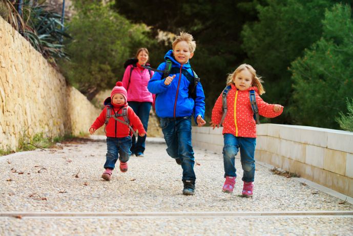 Three Siblings with backpacks on Running away from mom.